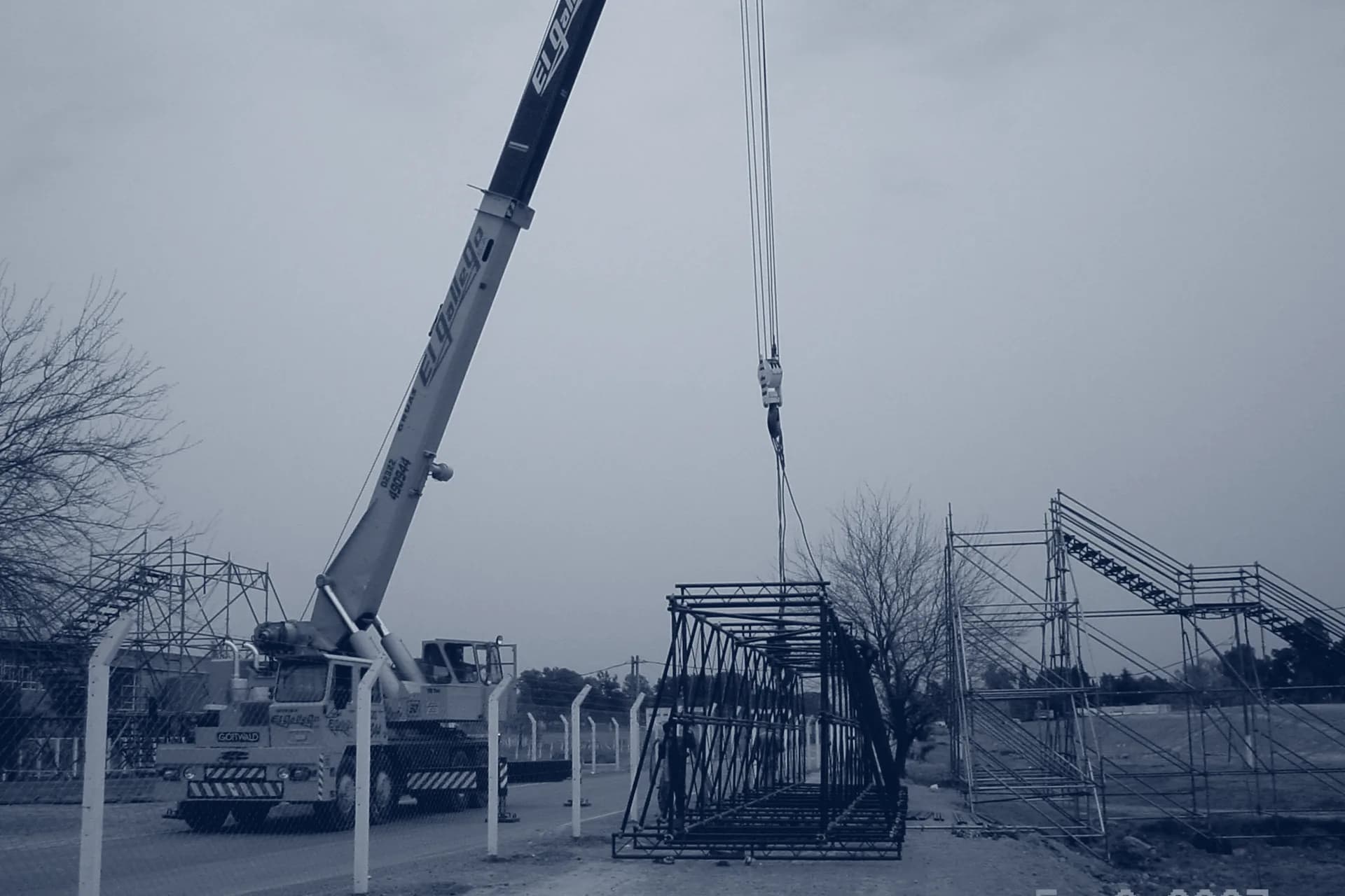Grúa izando el reticulado del puente peatonal sobre la Ruta Nacional 8